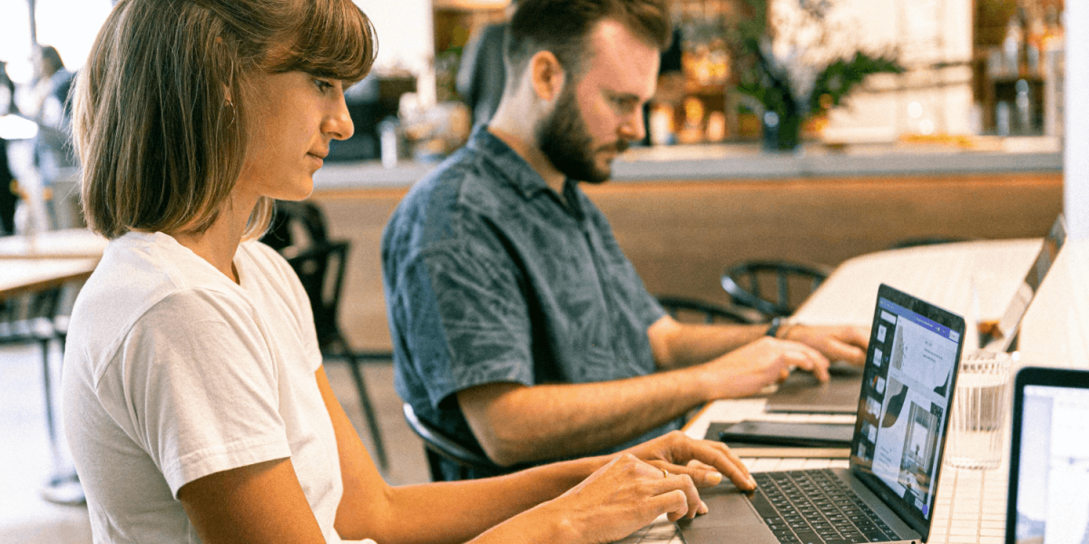 kobieta i mężczyzna przed laptopami