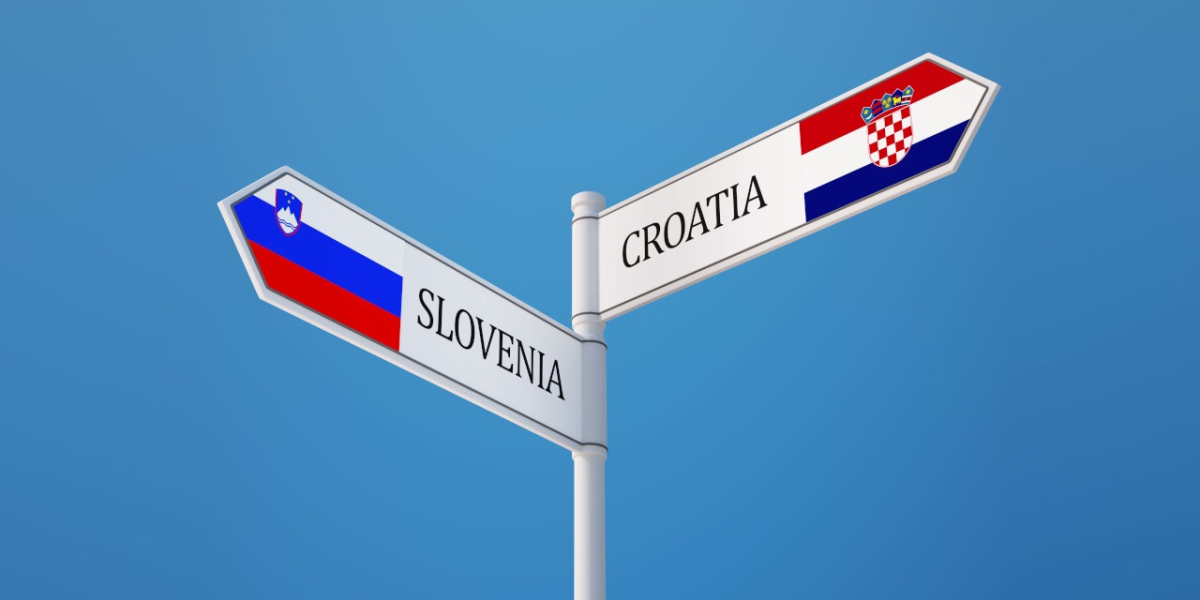 Drogowskaz z napisami Slovenia oraz Croatia na tle błękitnego nieba