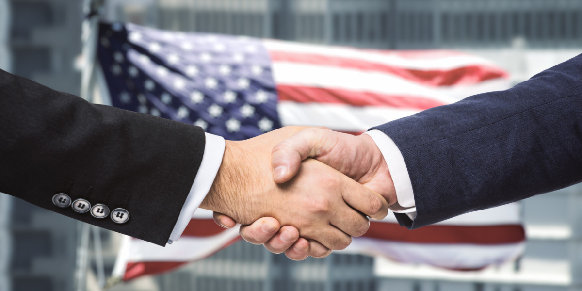 Uścisk dłoni na tle flagi USA