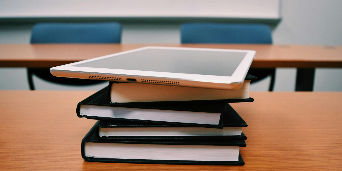 Stos książek i lezący na nich tablet