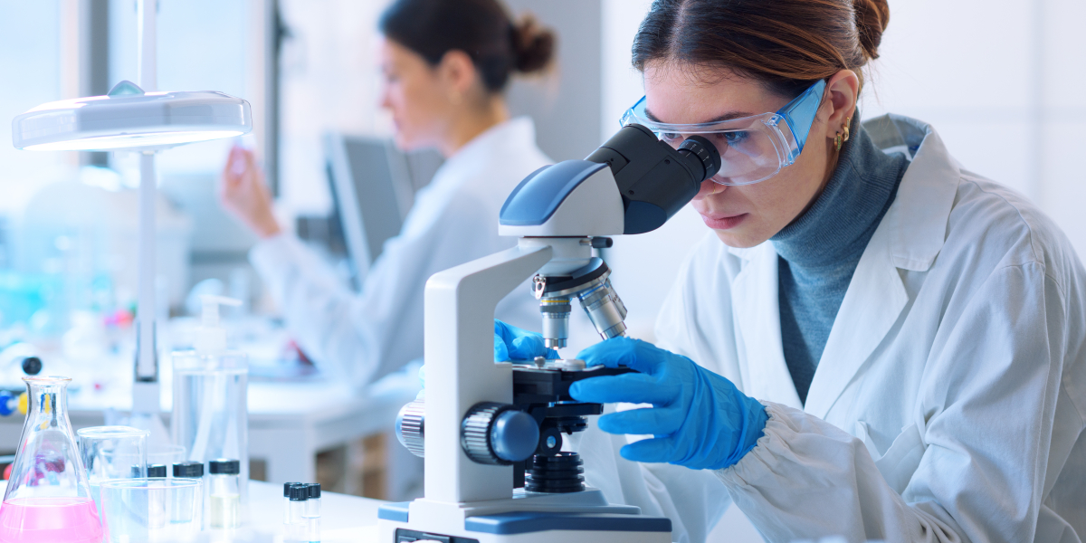 Kobieta przy mikroskopie w laboratorium.