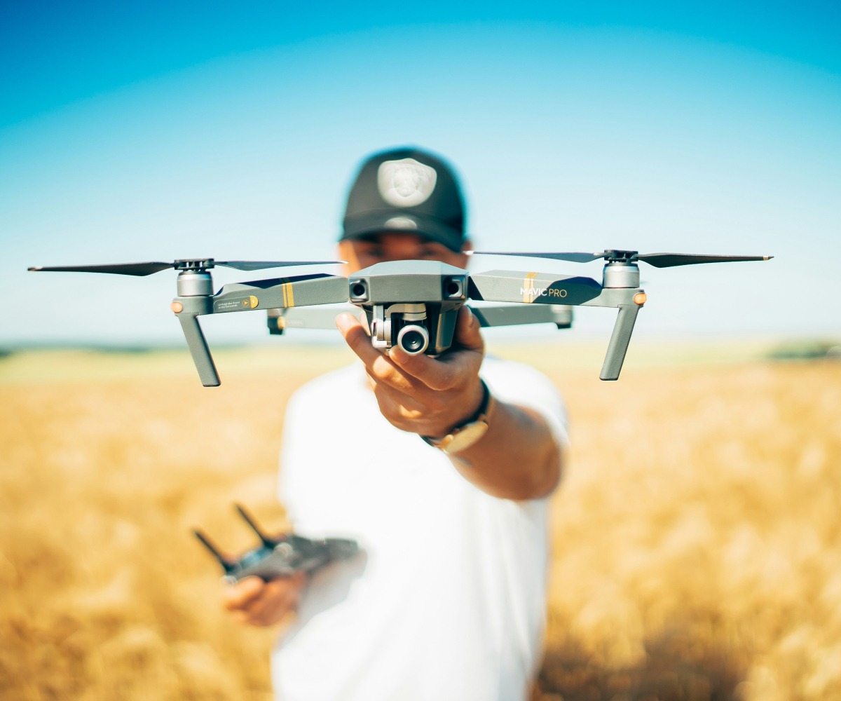 Mężczyzna z dronem na tle złocistego zboża