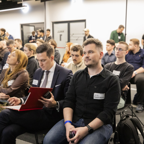 Grupa osób siedzących na widowni konferencji