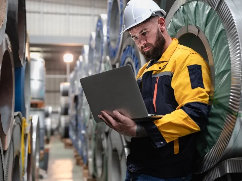 mężczyzna w kasku z laptoprem w ręce