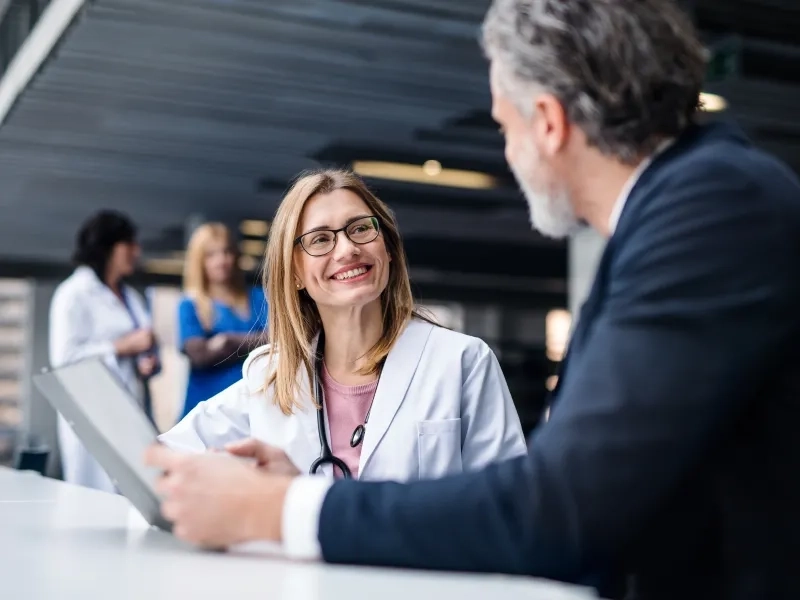 uśmiechnięta lekarka rozmawiająca z mężczyzną